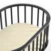 Black wooden baby bassinet with curved oval frame and elevated nursery design