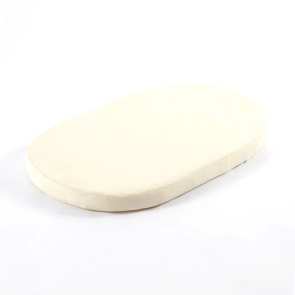 Cream baby bassinet mattress with rounded edges shown from an angled view
