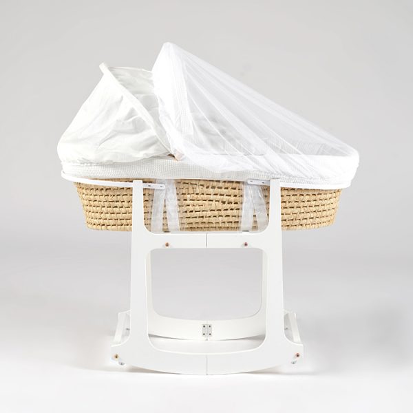 Side view of woven baby bassinet with white canopy and wooden rocking stand