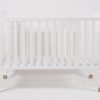 Front view of white wooden baby crib with wheels