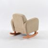 Rear angled view of beige corduroy baby rocking chair with upholstered back and natural wooden rockers
