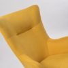 Close-up of mustard upholstered wingback rocking chair back