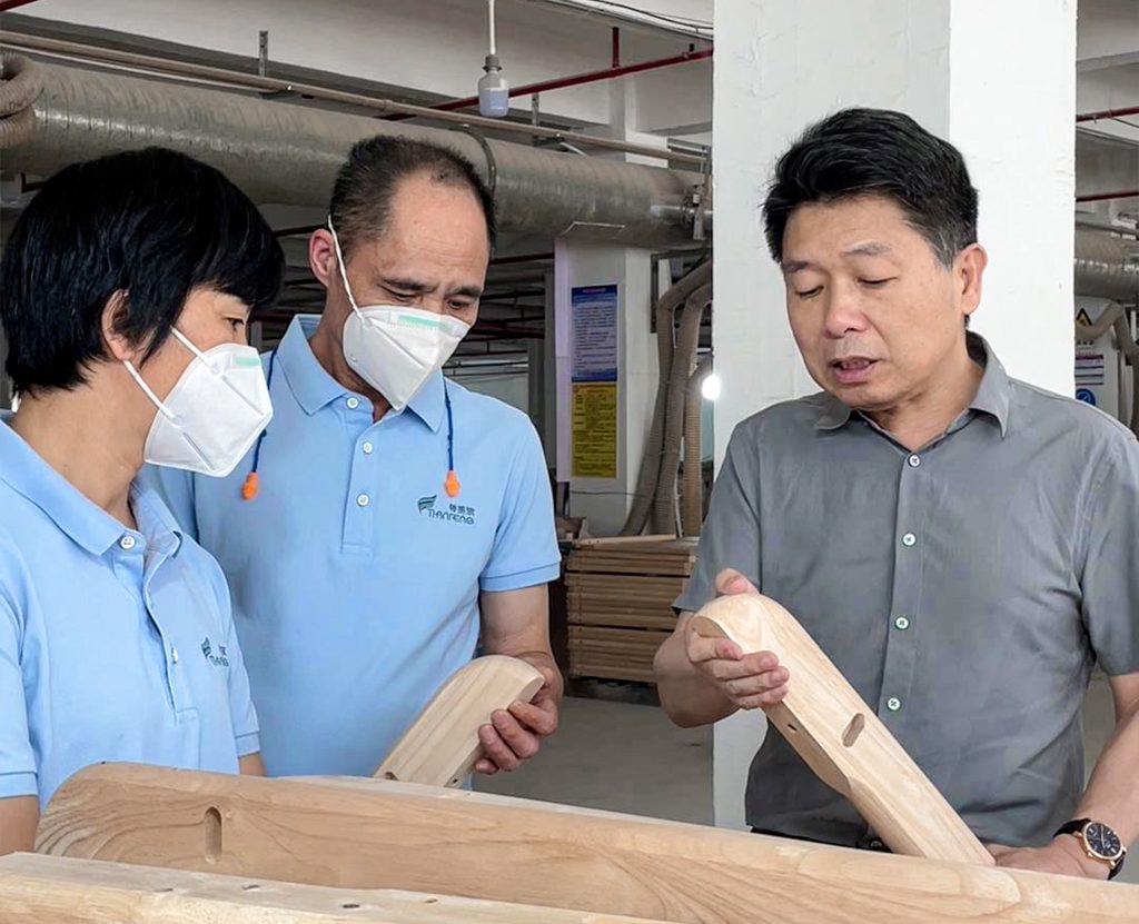 Tianfeng Baby team reviewing a wooden furniture sample