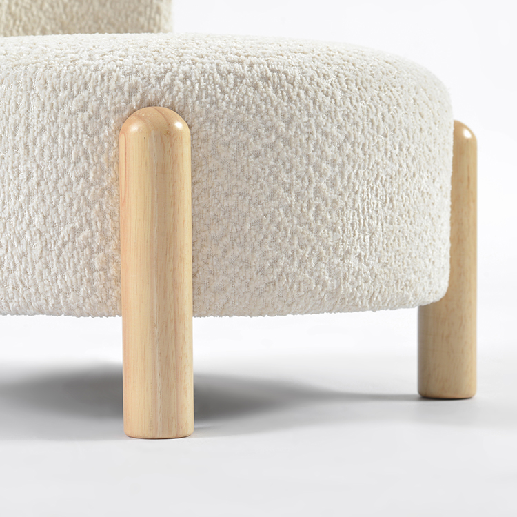 Close-up of textured bouclé kids chair upholstery and rounded natural wooden leg