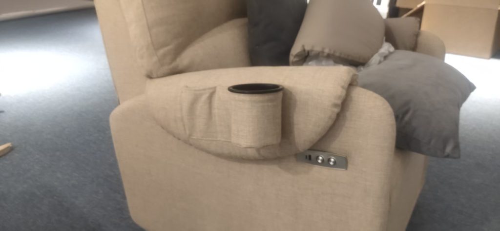 Close-up of relocated power recliner control buttons beside a custom armrest cup holder.